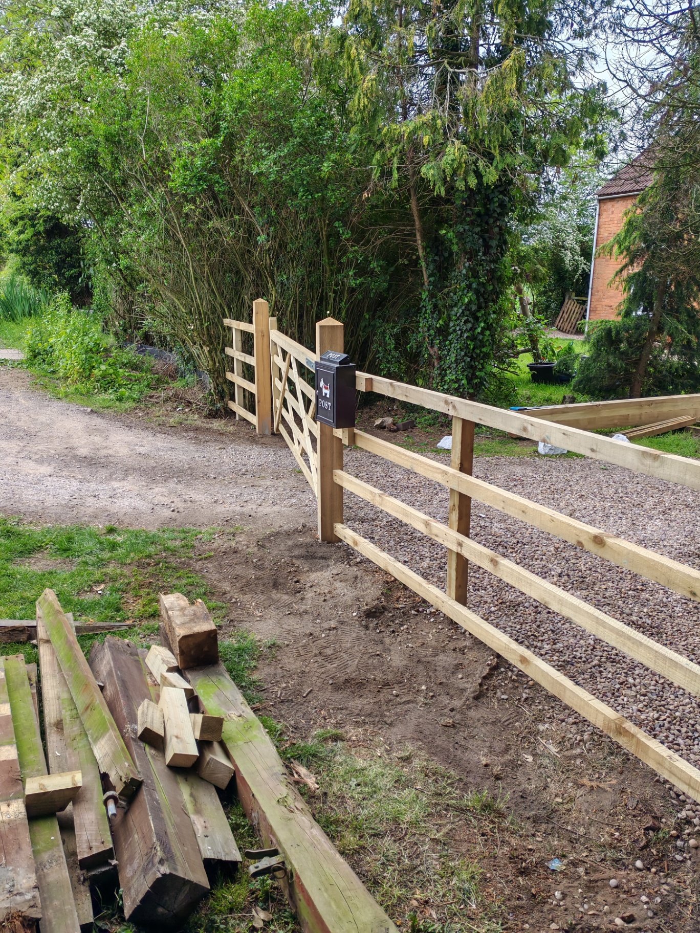 Completed post-and-rail fence run alongside the drive